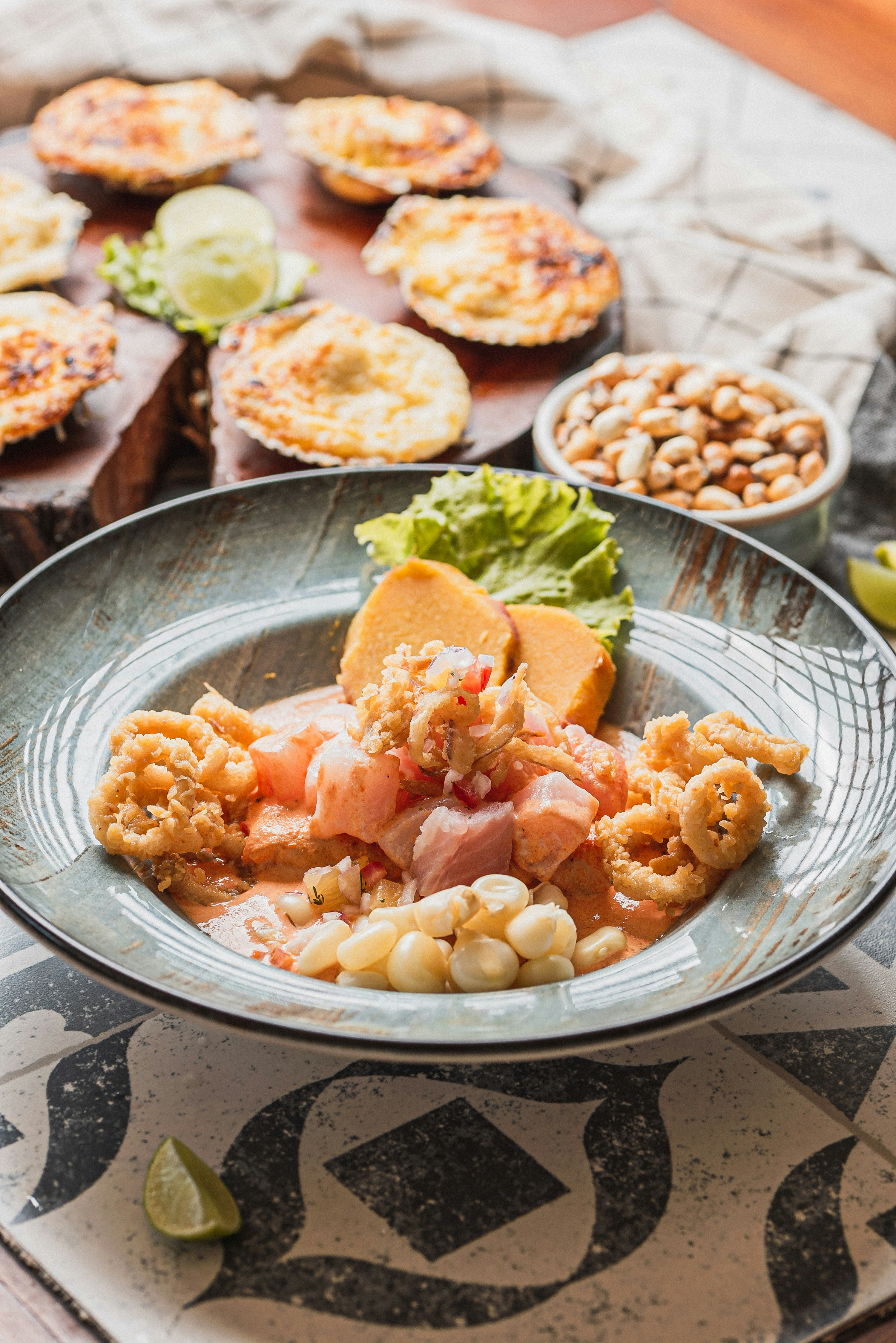 Peruvian ceviche with fried calamari, choclo and camote on a restaurant plate in Lima