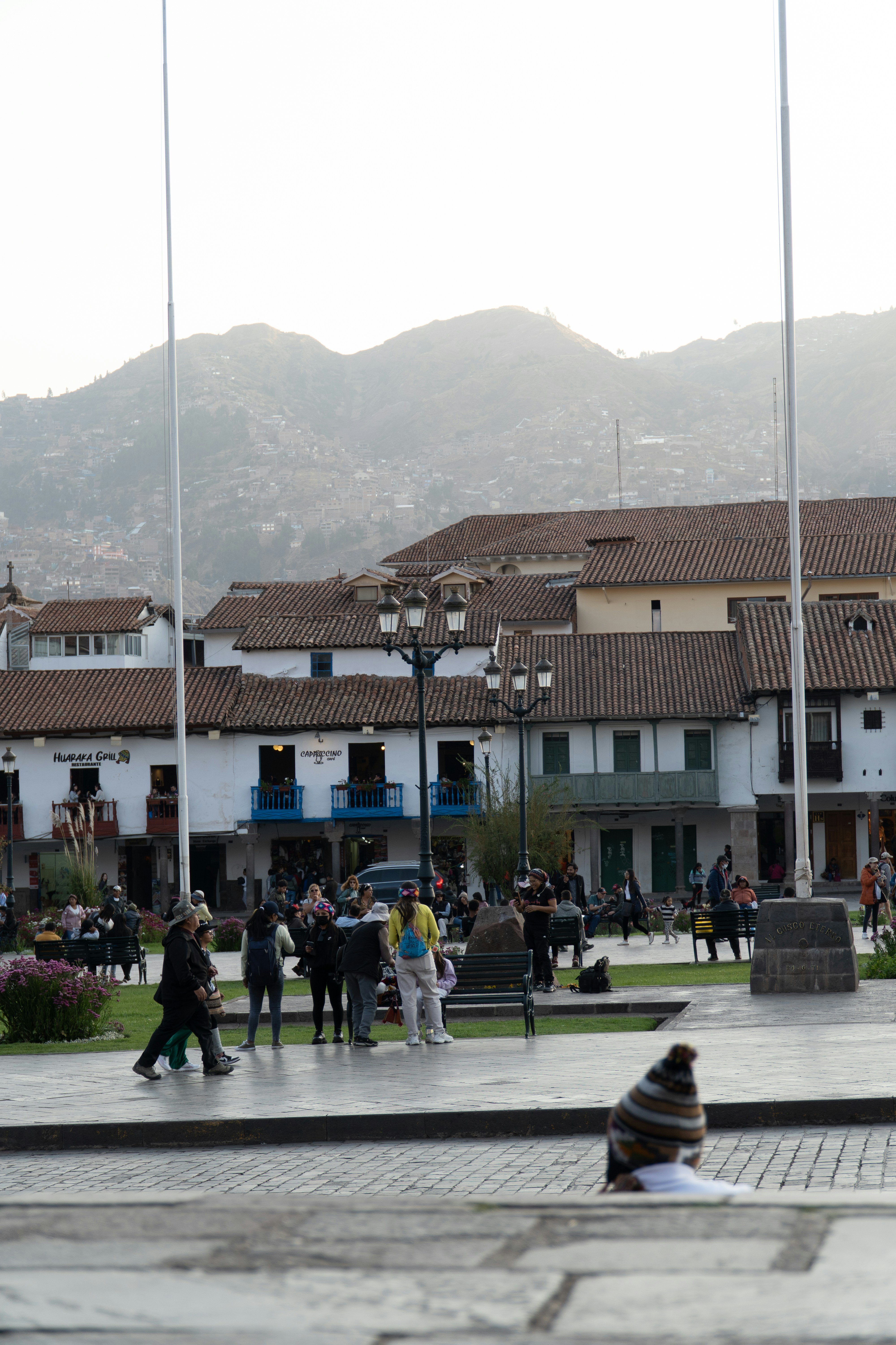 Cusco Plaza de Armas with colonial white buildings and Andean mountains behind, Peru