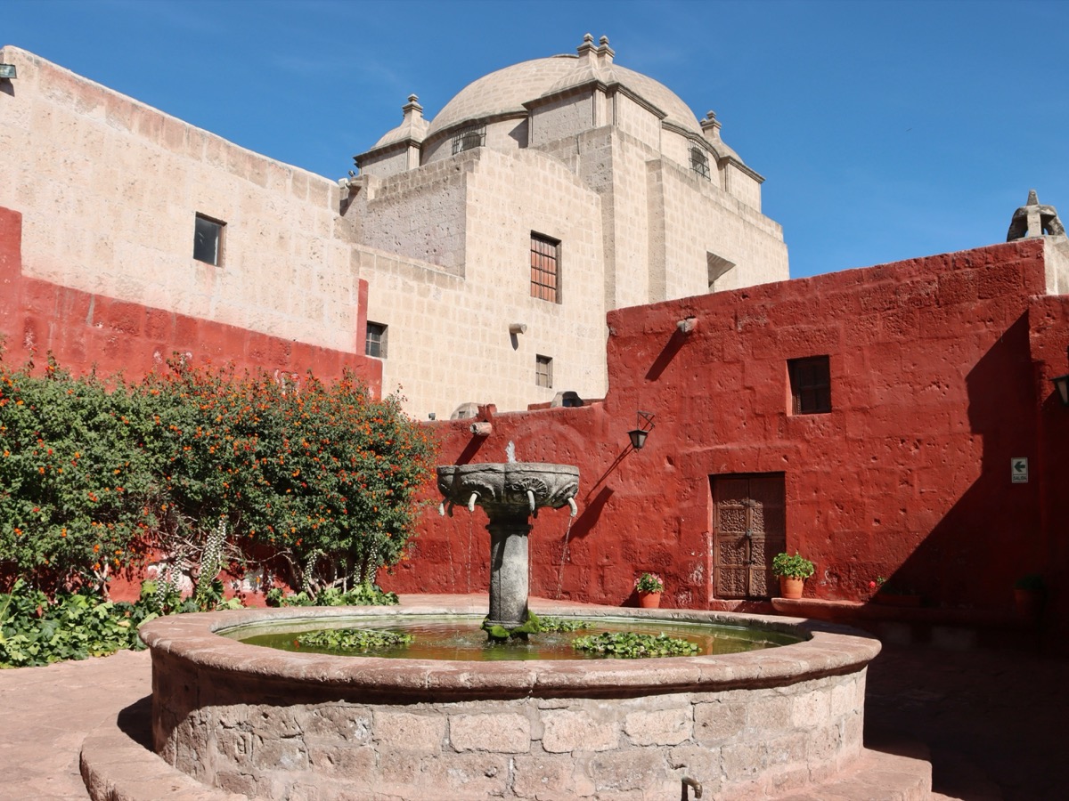 Santa Catalina Monastery courtyard with fountain and red colonial walls, Arequipa, Peru