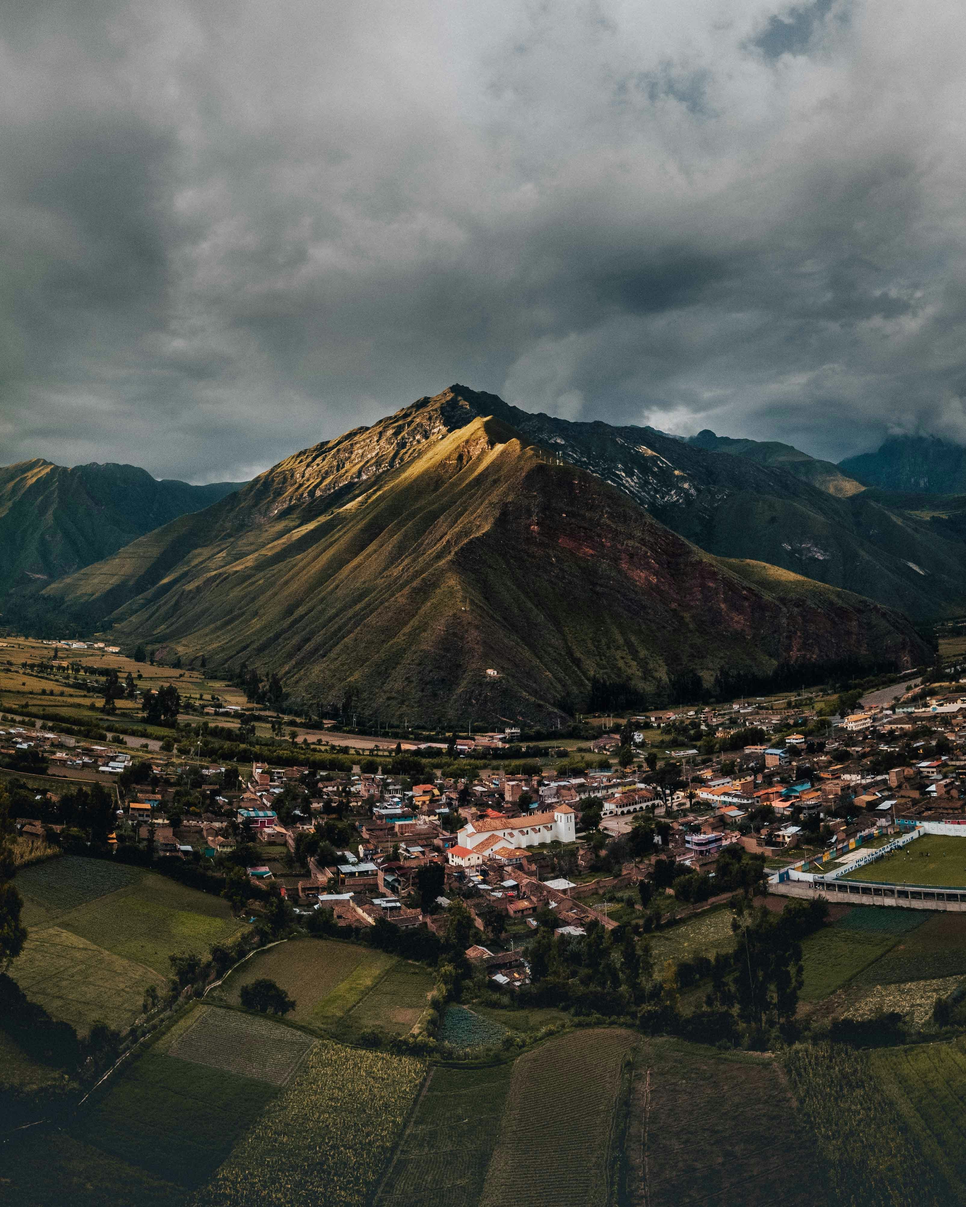 Small Andean town with terracotta rooftops beneath dramatic mountain slopes, northern Peru