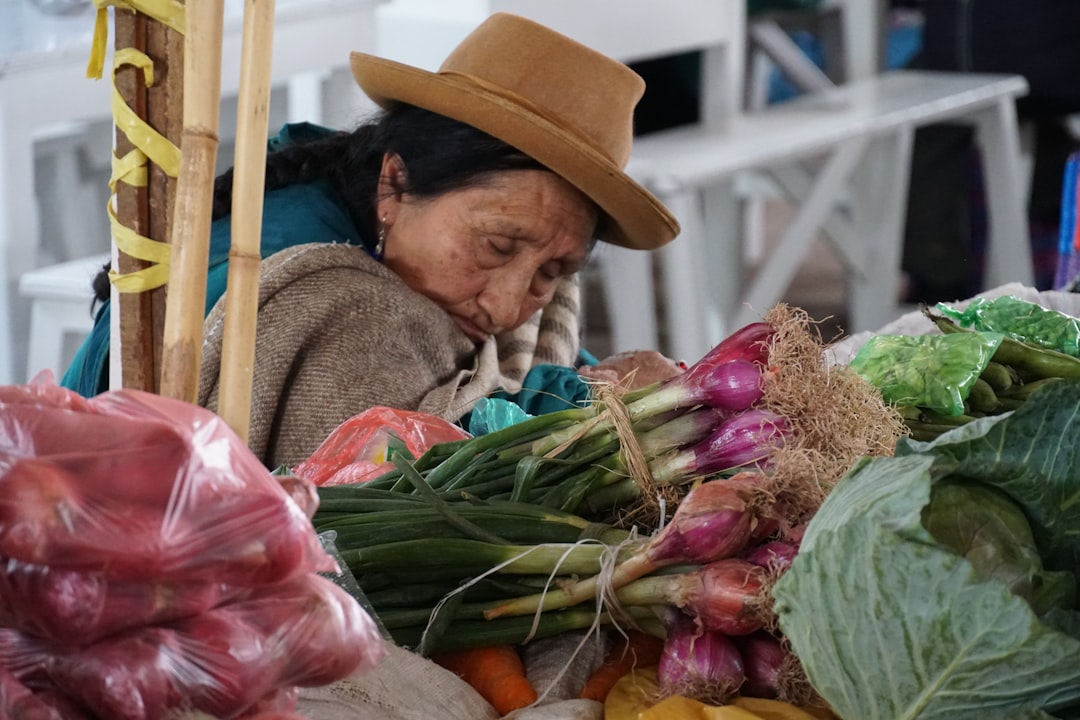 Andean woman selling fresh vegetables at a Cusco market stall