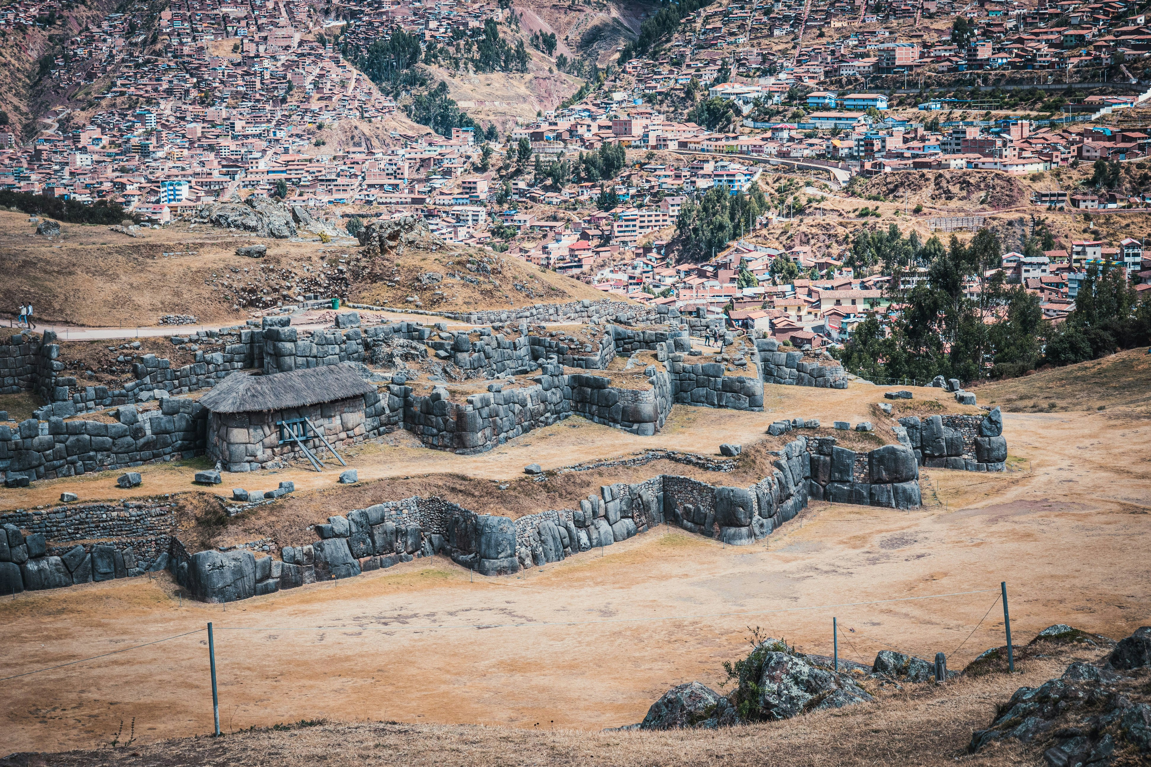 Sacsayhuamán zigzag stone walls with Cusco city spread across the valley below