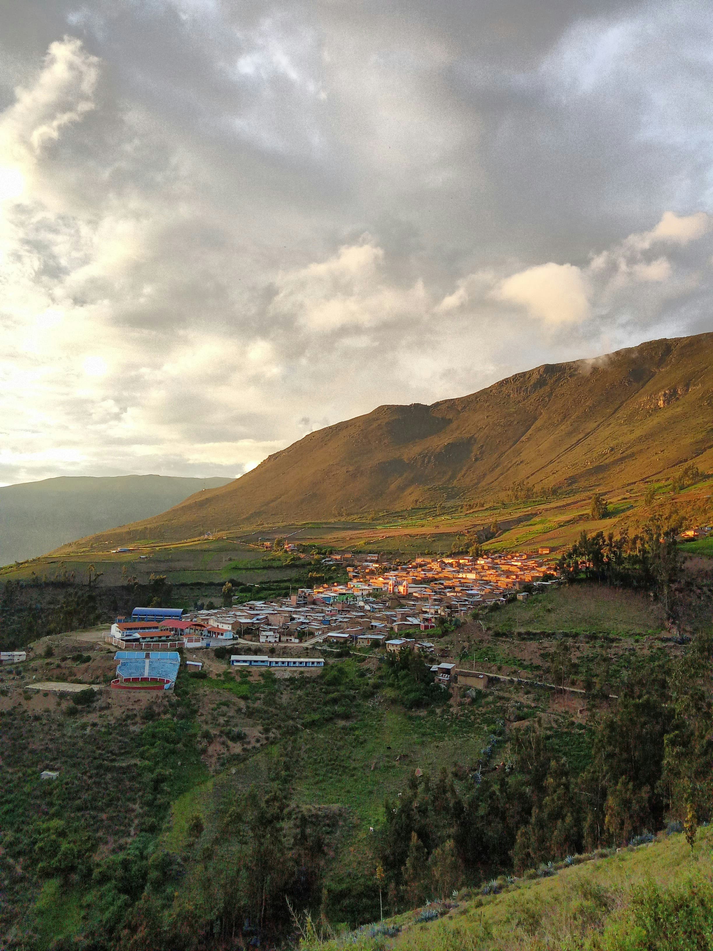 Small Andean village nestled below mountain slopes at dusk, northern Peru
