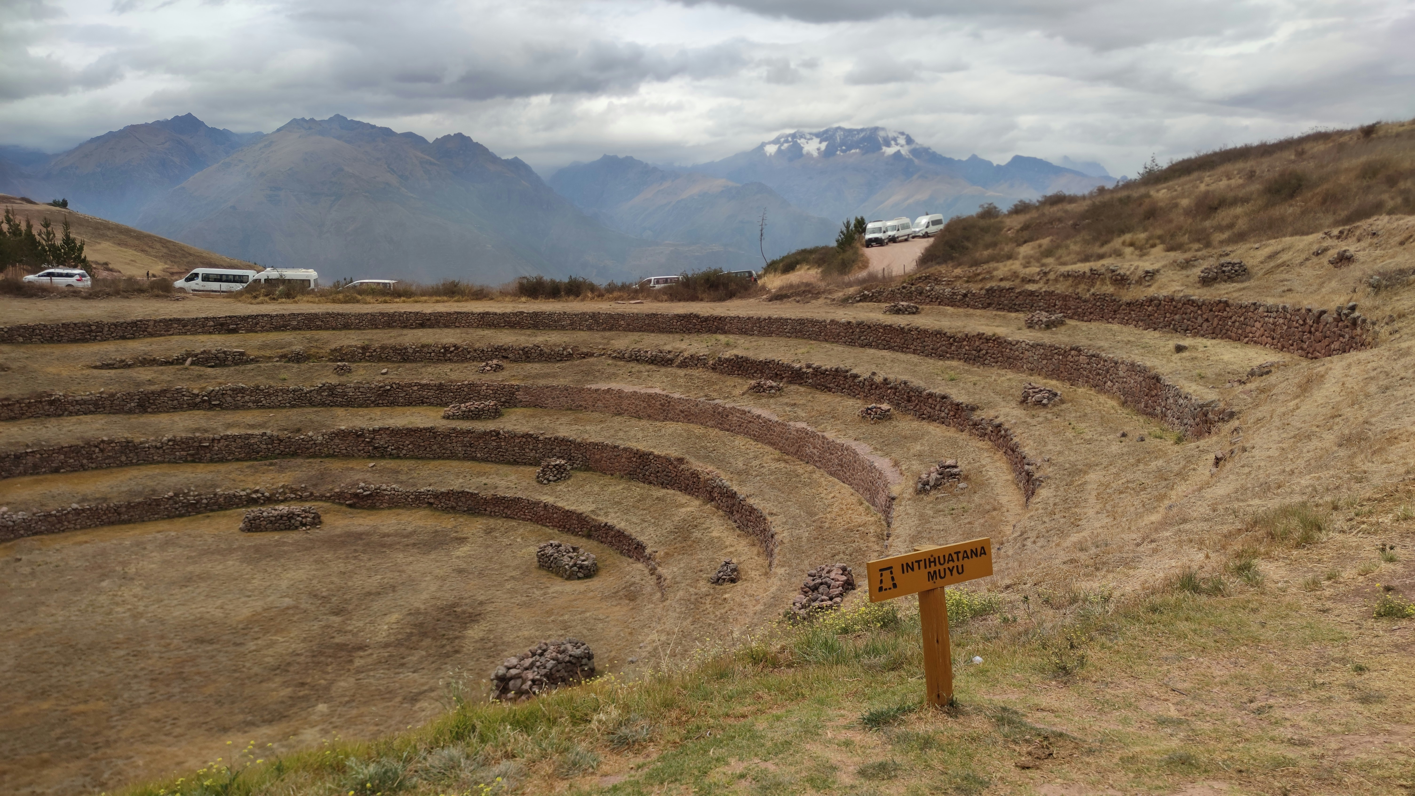 Ancient circular Inca terraces at Moray in Peru's Sacred Valley with snow-capped mountains behind