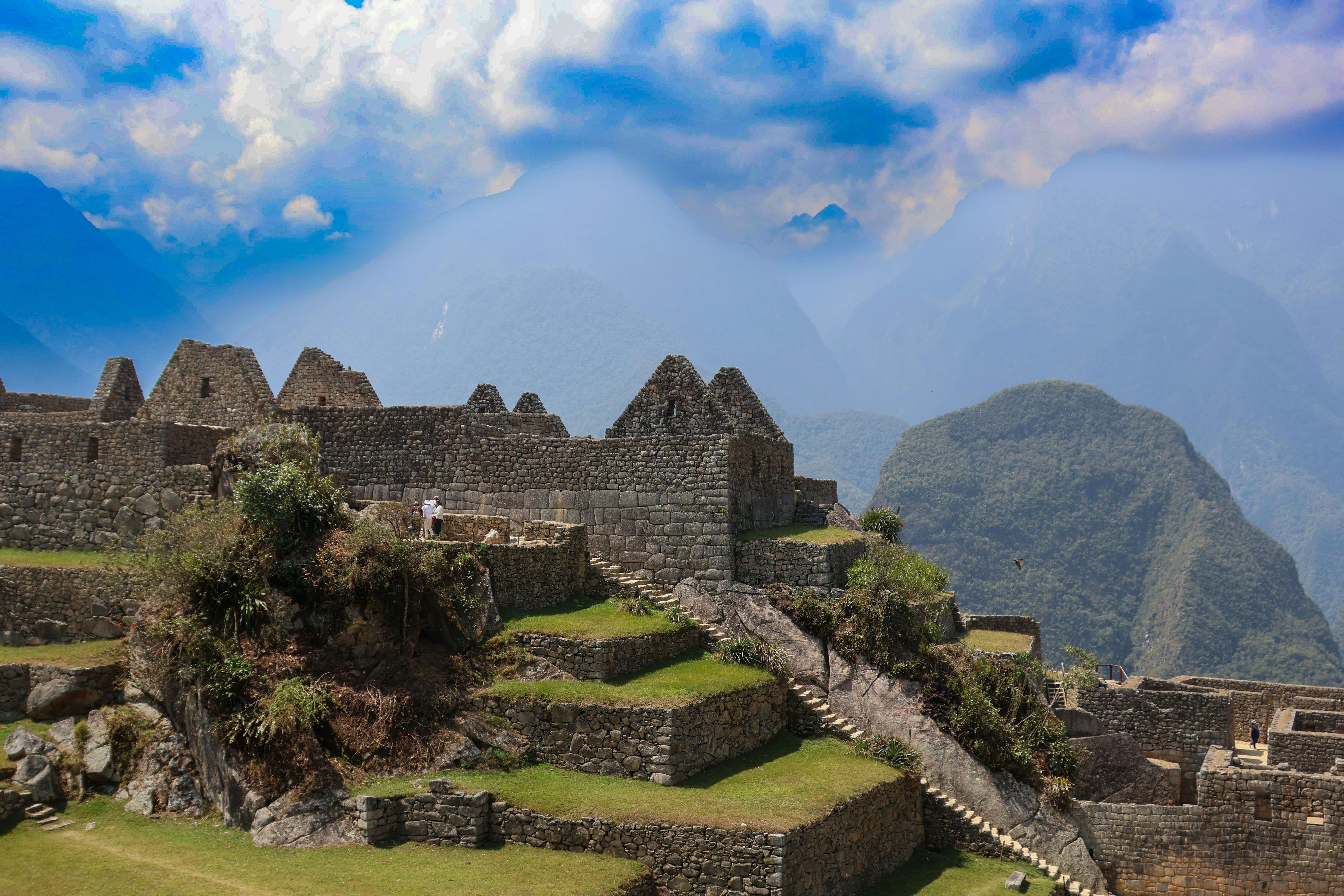 Machu Picchu stone buildings and terraces in sunlight with mountain backdrop, Peru