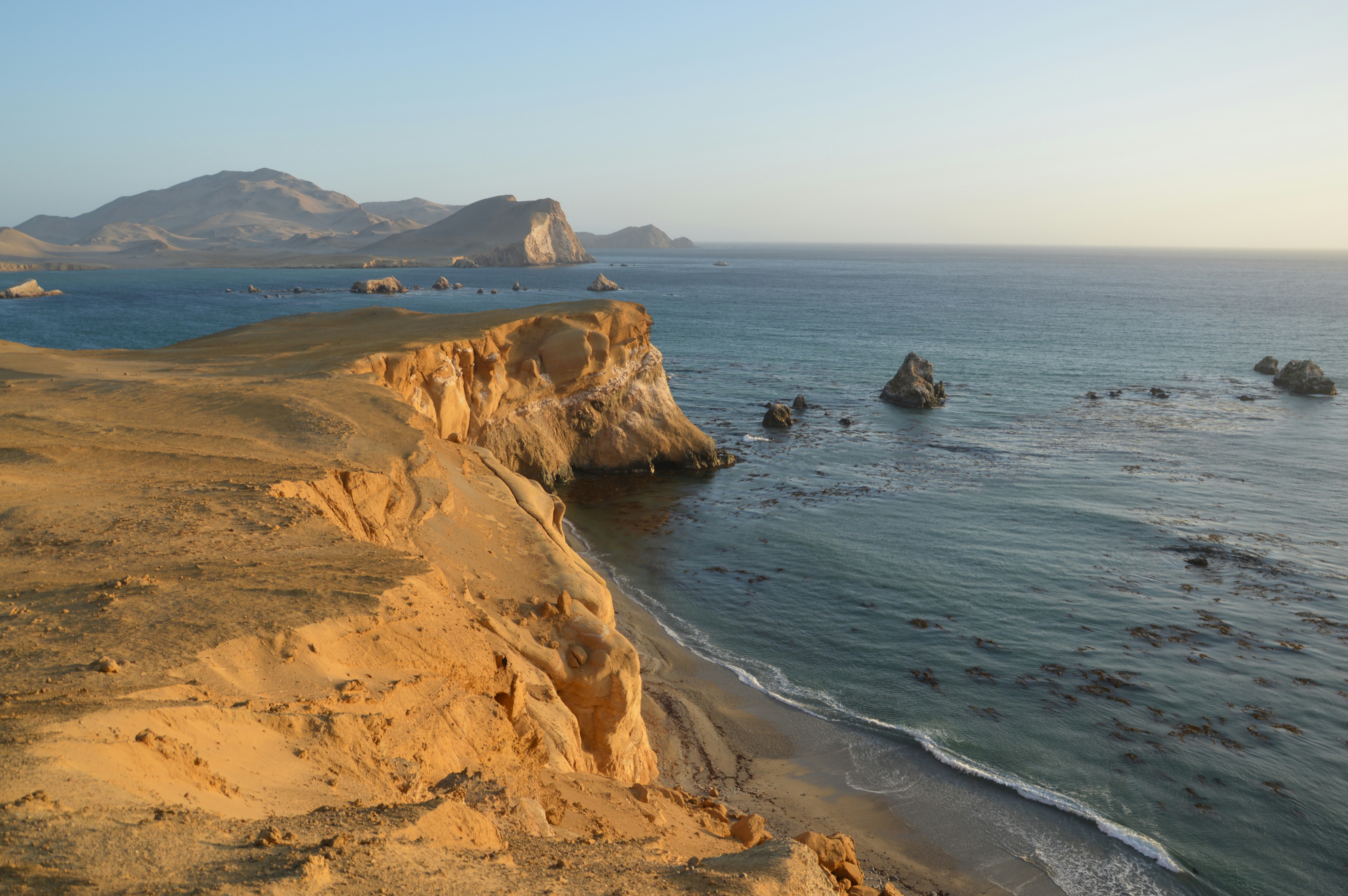 Coastal cliffs of the Paracas National Reserve meeting the Pacific Ocean, Peru
