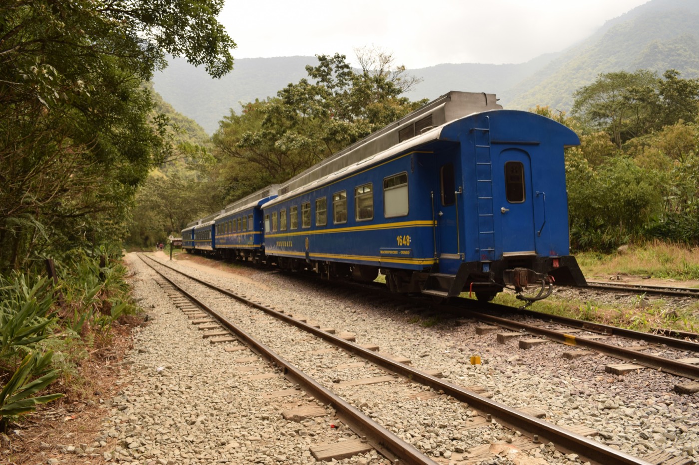 Blue PeruRail train on the tracks near Machu Picchu Pueblo, Peru
