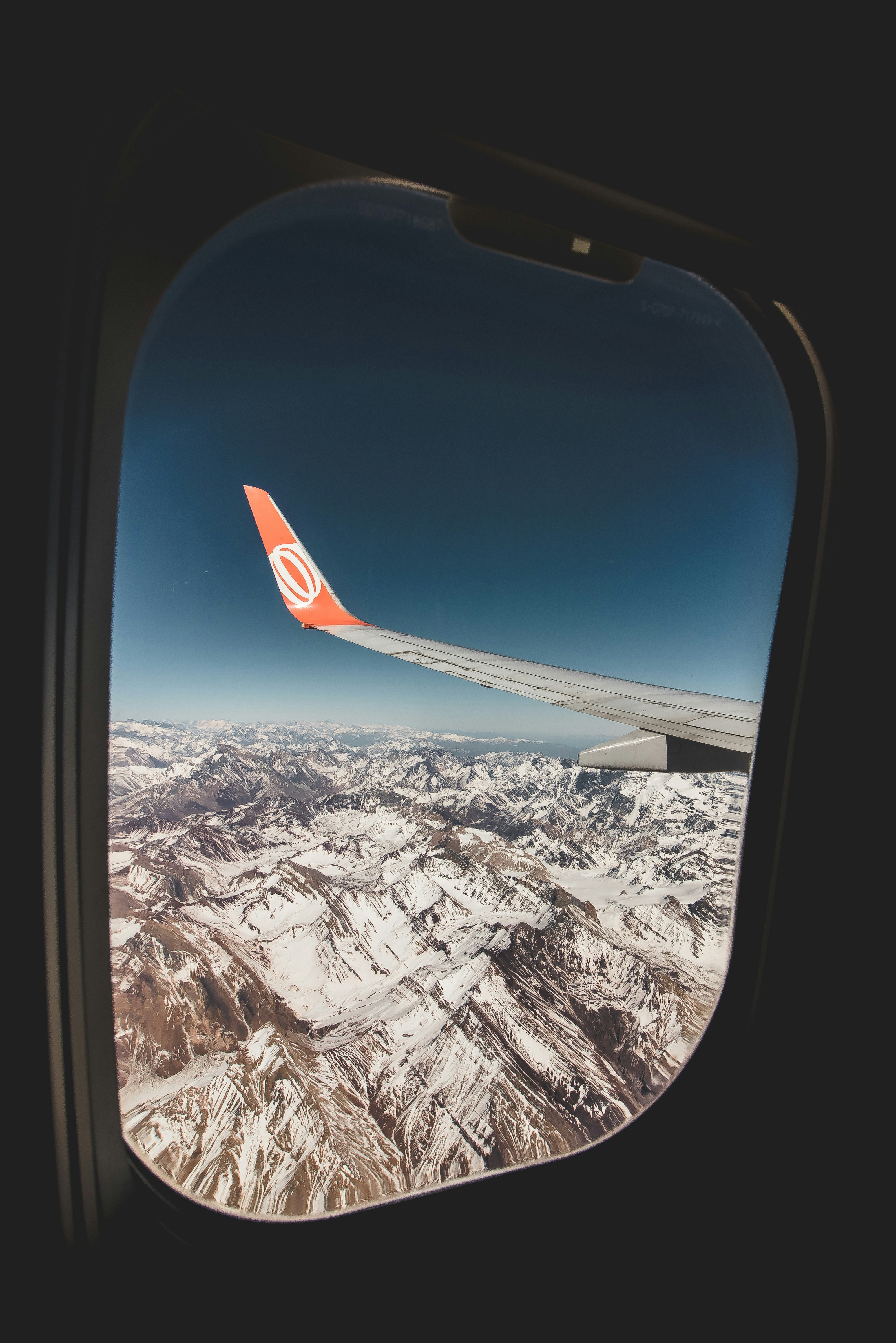 View from airplane window over snow-capped Andes mountains on the Lima to Cusco route