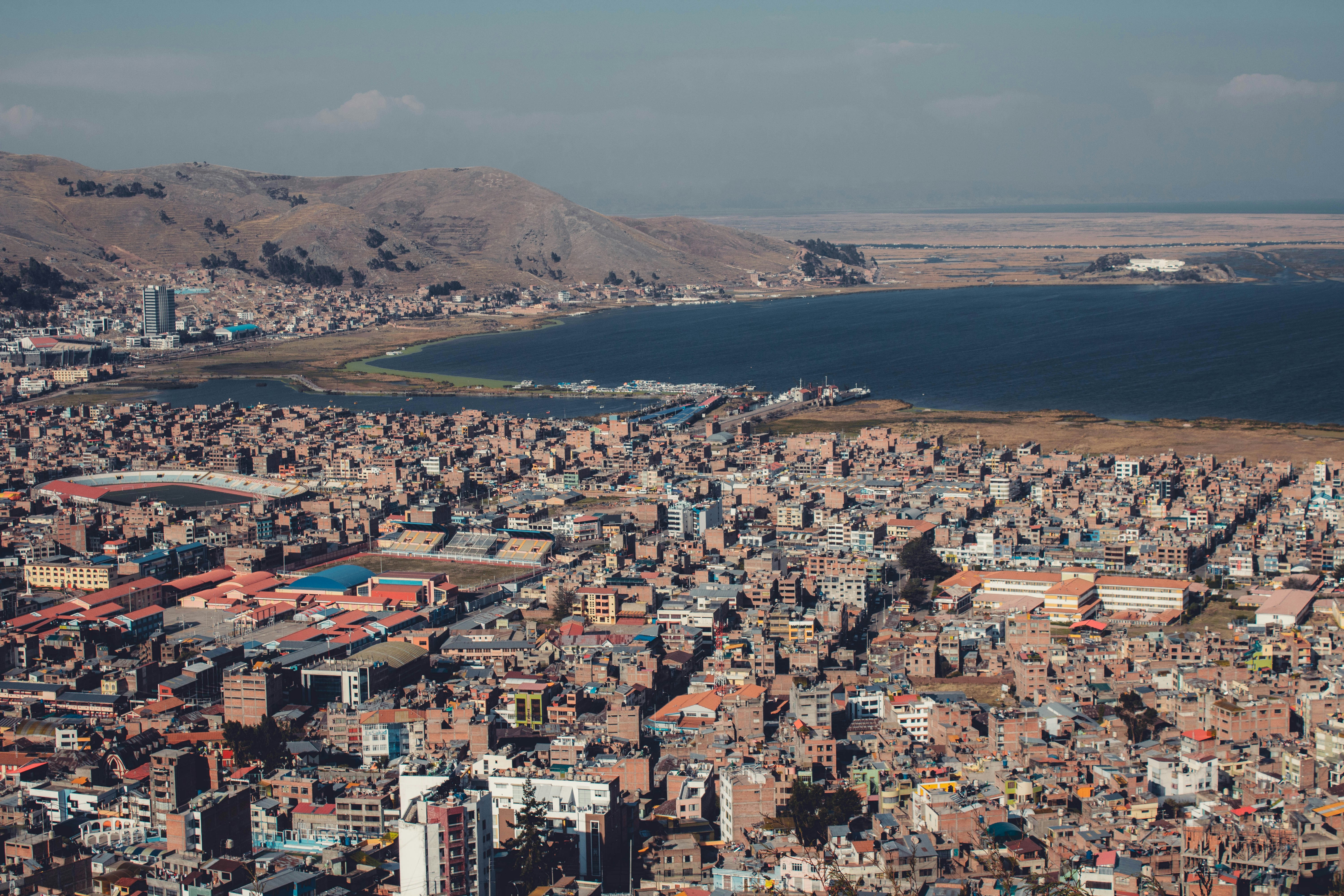 Aerial view of Puno city rooftops and buildings beside Lake Titicaca, Peru