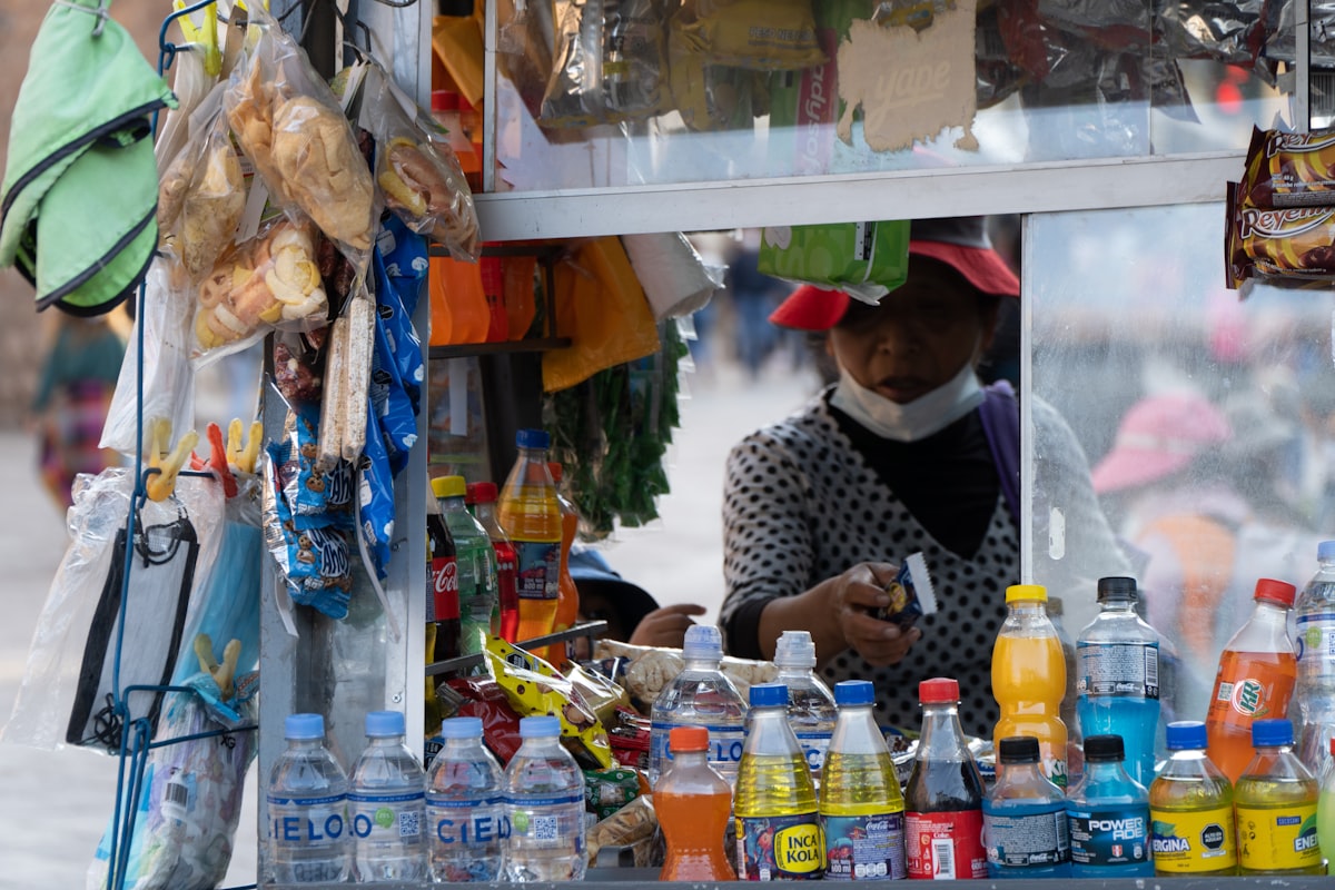Street vendor stall in Cusco selling snacks and drinks including Inca Kola