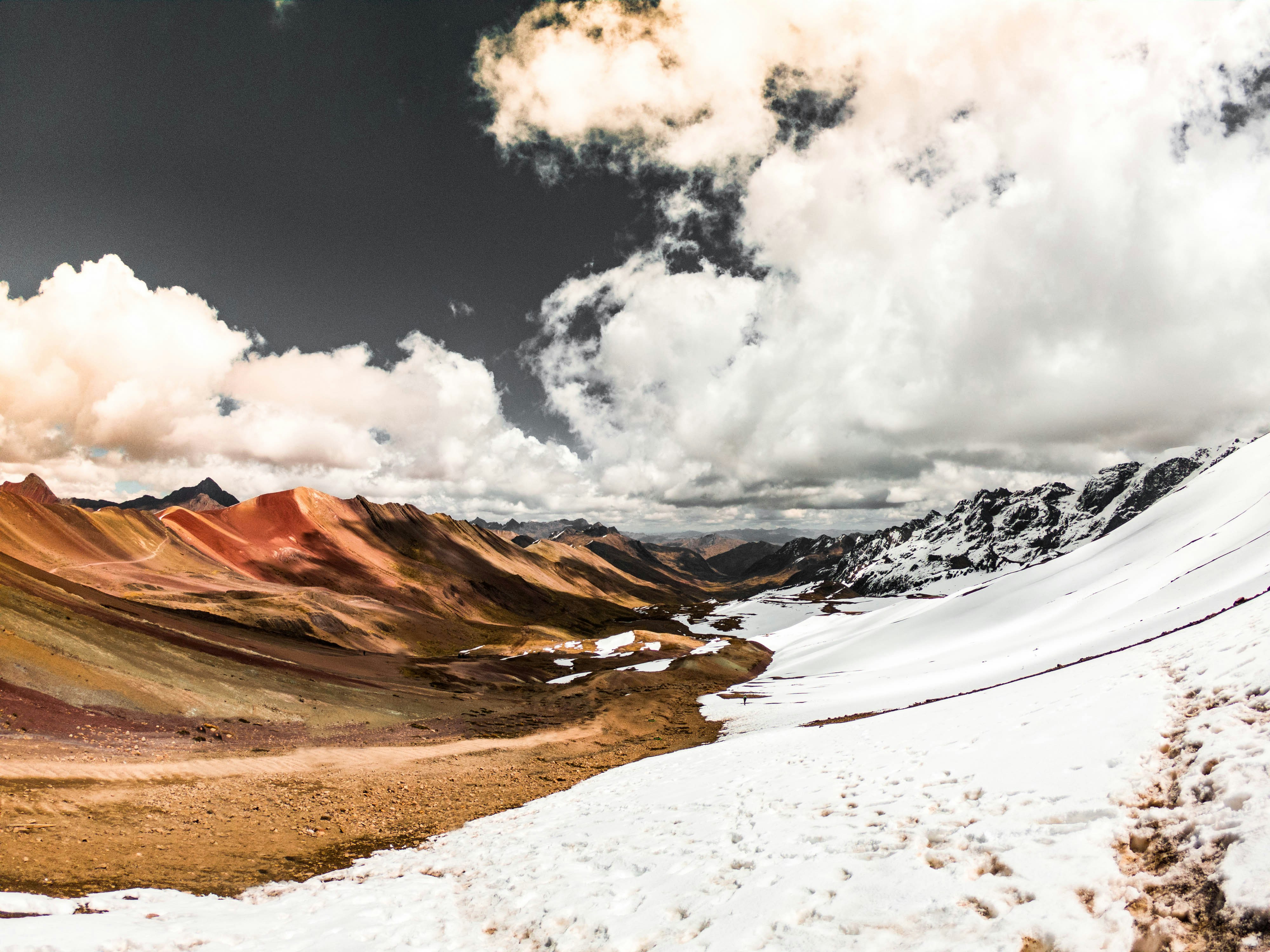Colourful mineral-streaked high-altitude mountains with snow along the Ausangate Trek, Cusco region, Peru