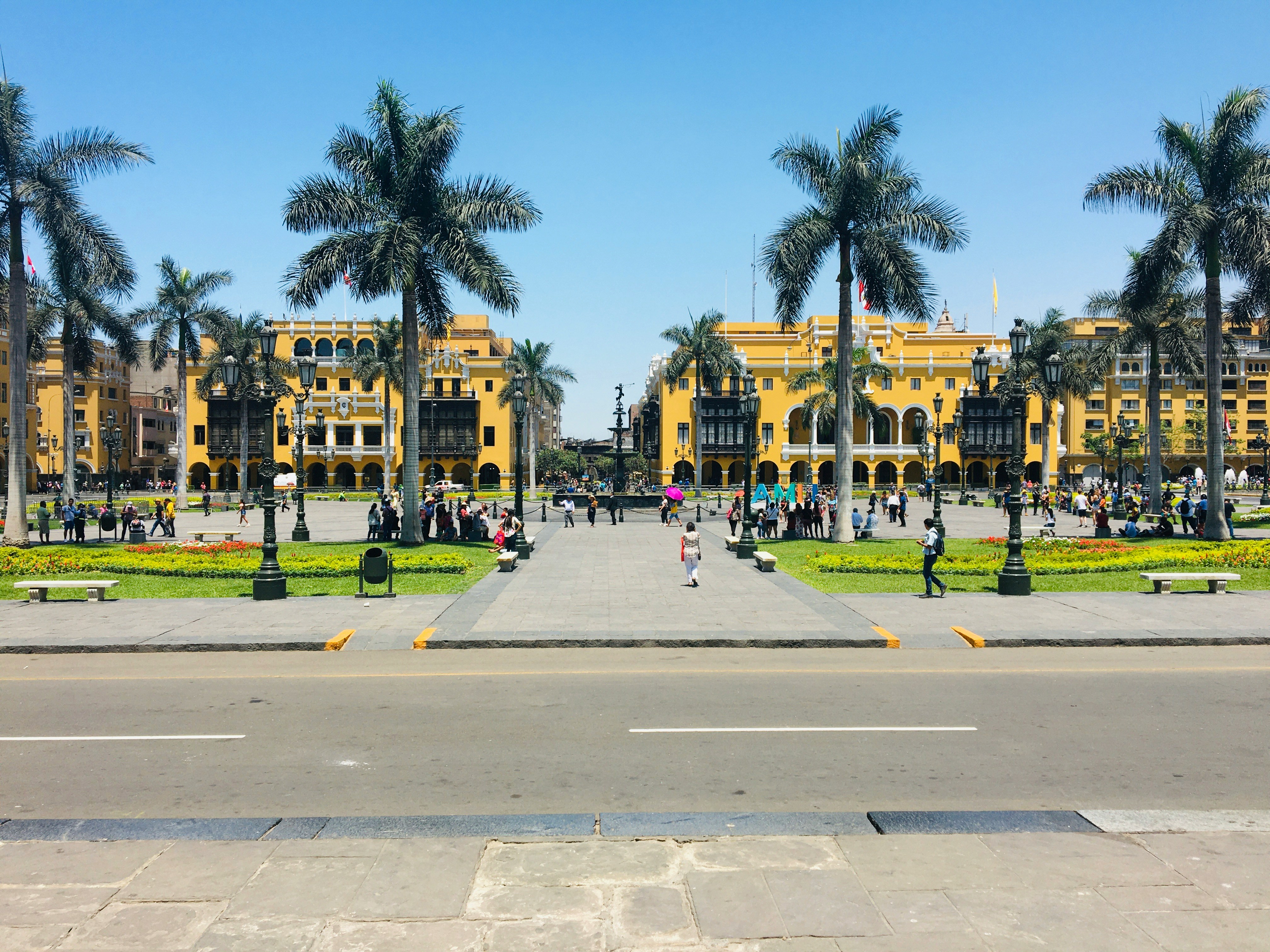 Yellow colonial Government Palace building at Lima's Plaza Mayor under blue sky, Peru